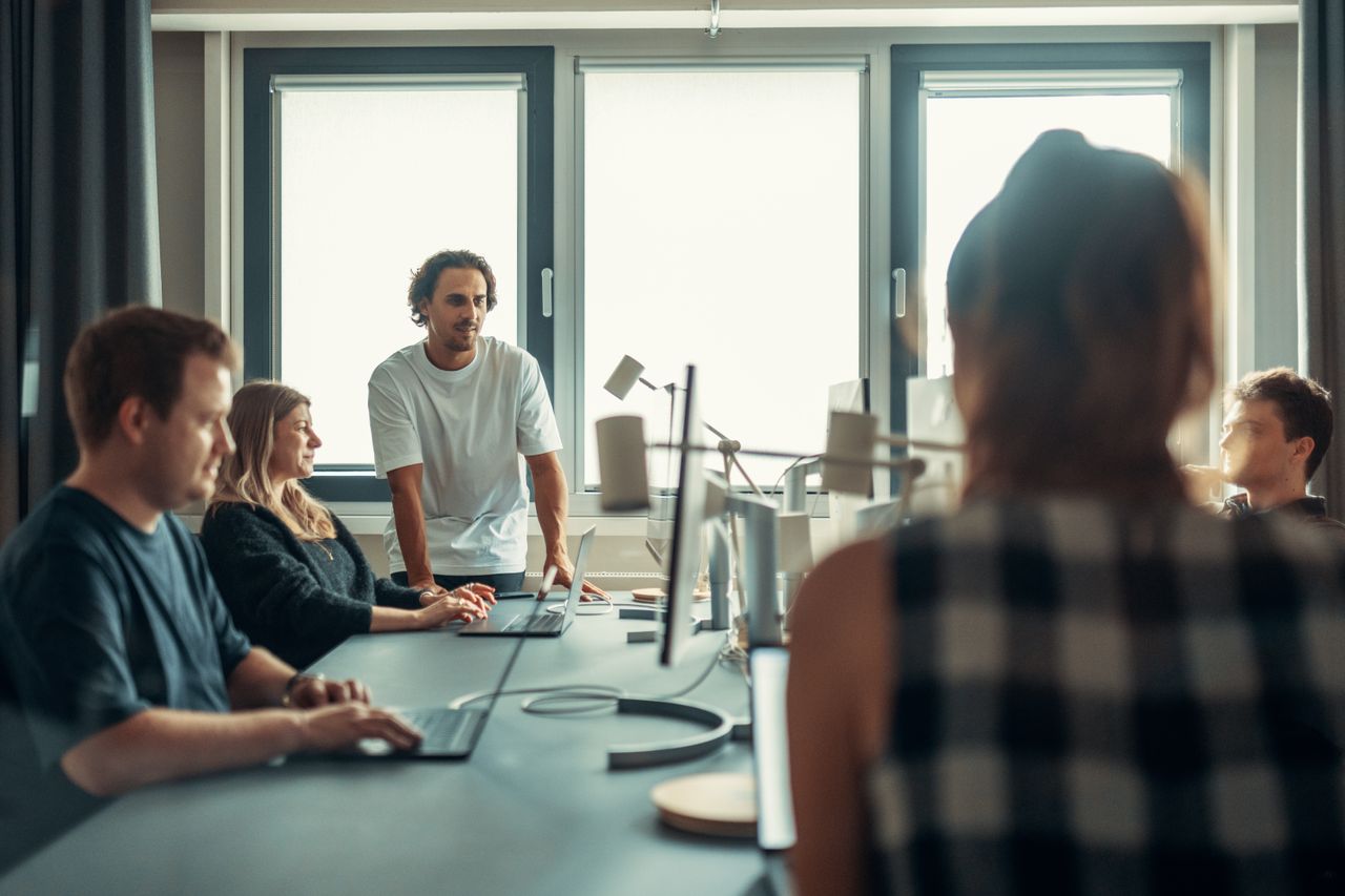 Une équipe variée échange lors d’une réunion collaborative au bureau.